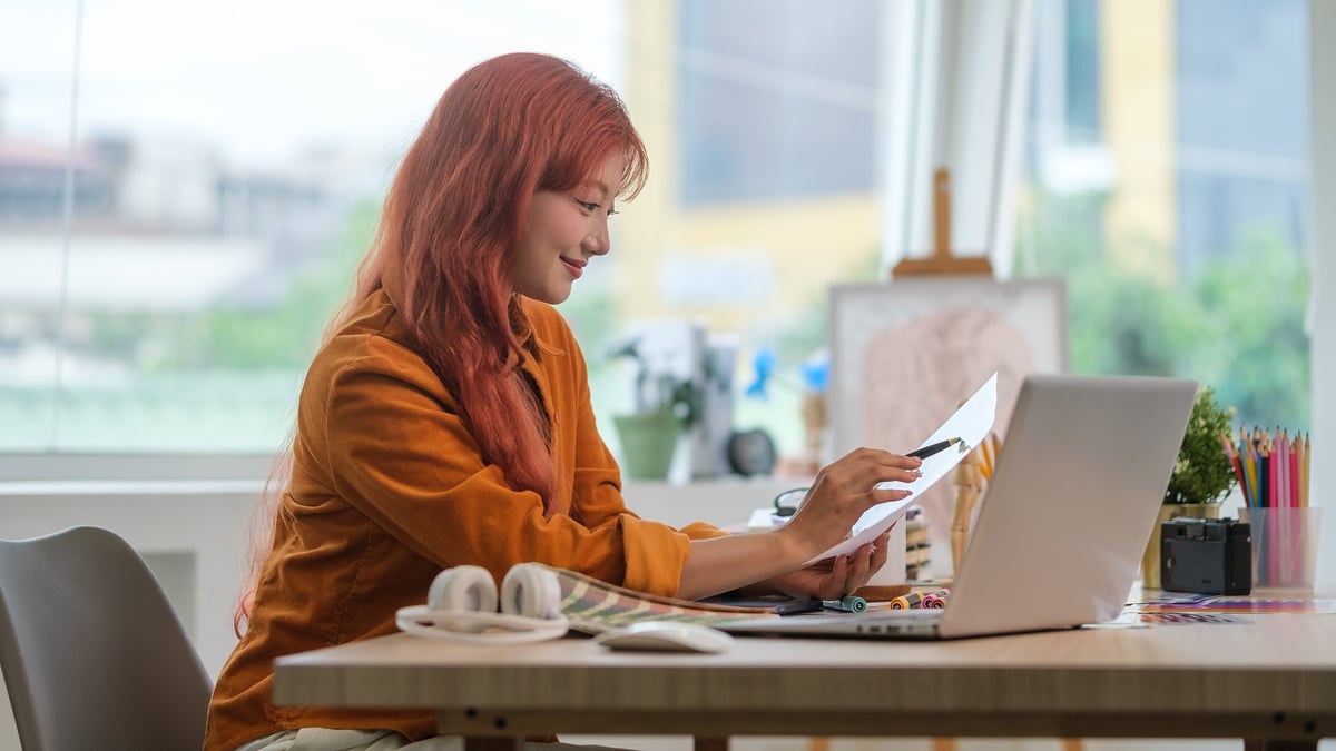Female graphic designer using laptop and selecting colors for her project